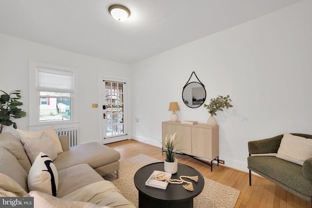 living room featuring radiator, light wood-type flooring, and baseboards