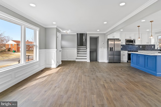 kitchen with a healthy amount of sunlight, blue cabinetry, stainless steel appliances, and light countertops