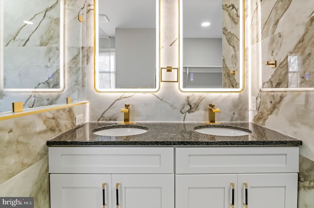 bathroom featuring double vanity, tile walls, and a sink