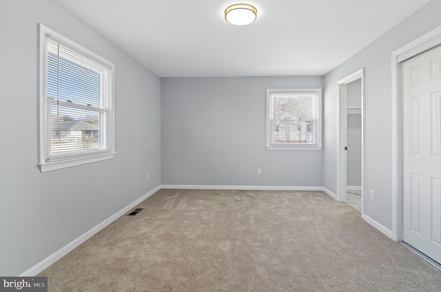 unfurnished bedroom with carpet floors, baseboards, and visible vents