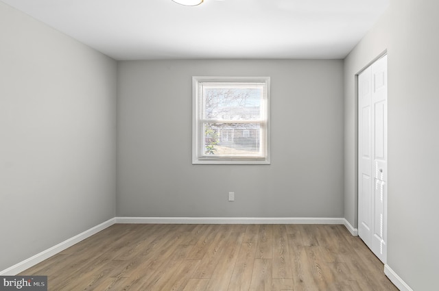 unfurnished room with baseboards and light wood finished floors