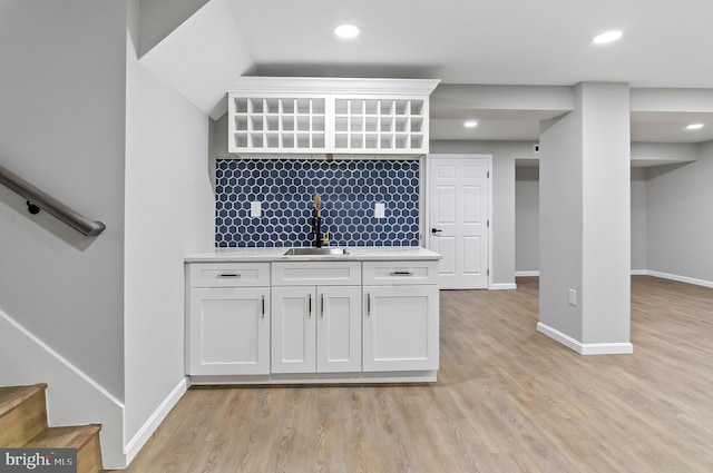 interior space with light wood-style floors, a sink, and baseboards