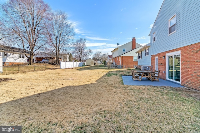 view of yard featuring a patio area, fence, and a residential view