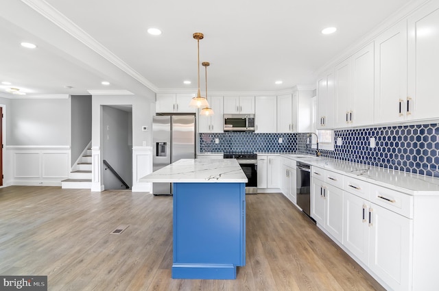 kitchen featuring stainless steel appliances, a center island, white cabinets, and light wood finished floors