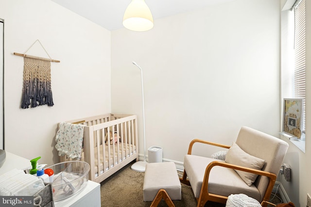 bedroom featuring multiple windows, baseboards, a nursery area, and carpet floors