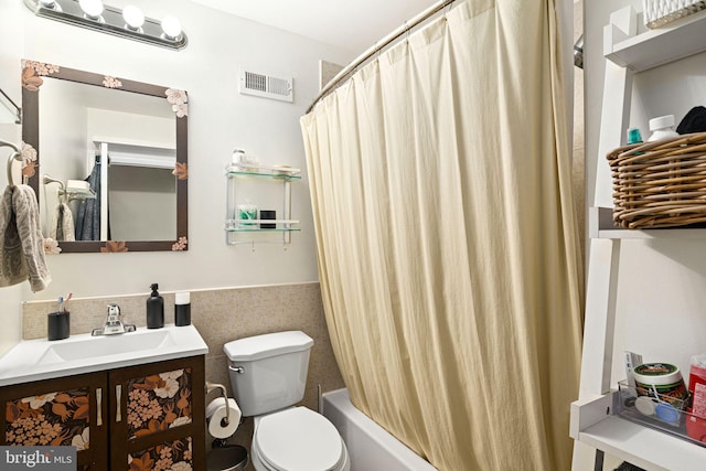 full bathroom with visible vents, a wainscoted wall, toilet, tile walls, and vanity