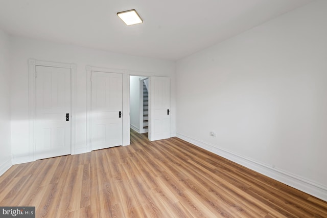 unfurnished bedroom featuring light wood finished floors and baseboards