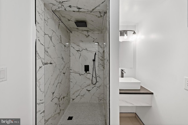 bathroom with visible vents, vanity, and a marble finish shower