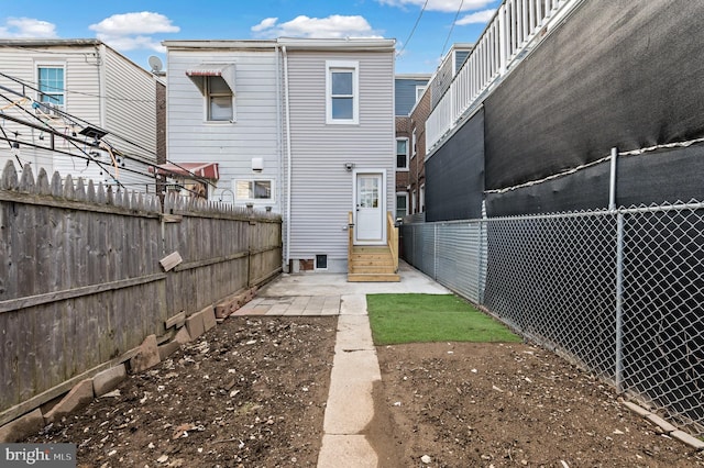 rear view of property with entry steps and fence