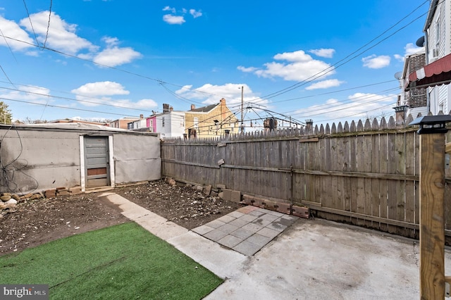 view of patio featuring an outbuilding and fence