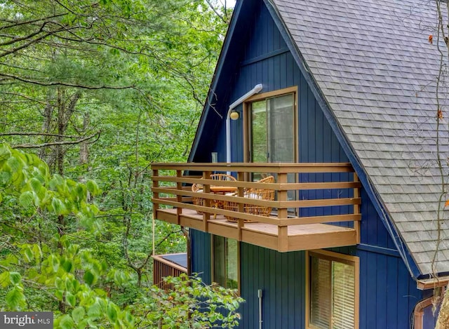 view of side of home with a shingled roof and board and batten siding