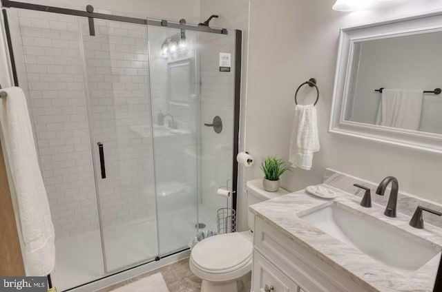 bathroom featuring toilet, a stall shower, and vanity