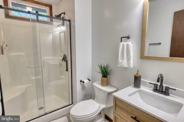 bathroom featuring a shower stall, toilet, and vanity