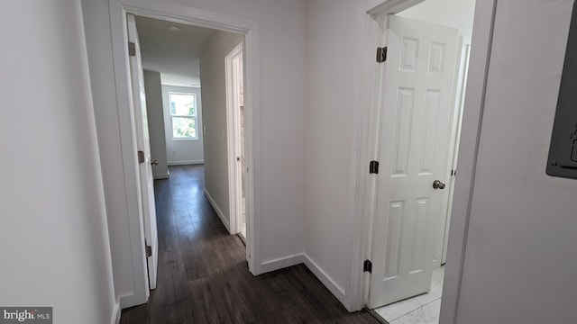 hallway featuring wood finished floors and baseboards