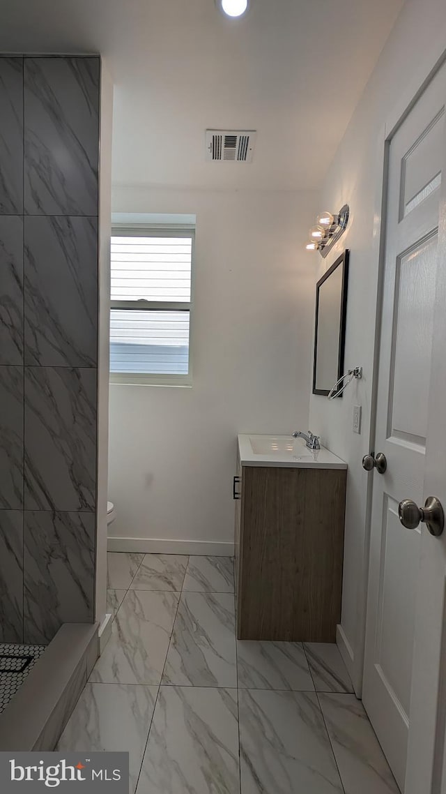 full bathroom featuring toilet, vanity, visible vents, baseboards, and marble finish floor