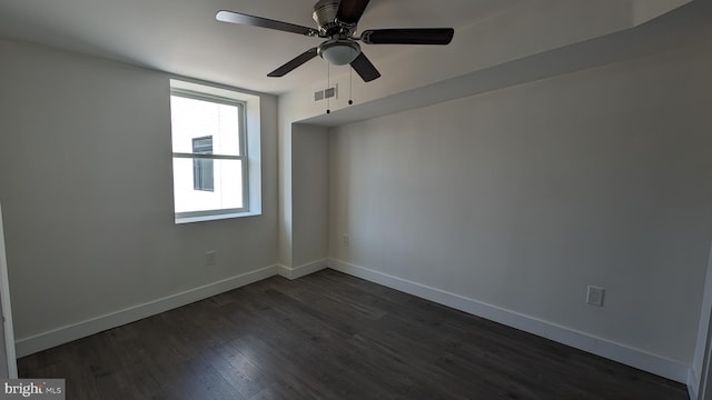 unfurnished room featuring dark wood-style floors, ceiling fan, visible vents, and baseboards