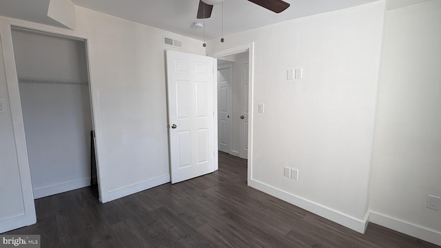 unfurnished bedroom with a closet, visible vents, dark wood-type flooring, a ceiling fan, and baseboards