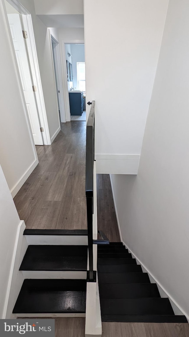 stairway with baseboards and wood finished floors