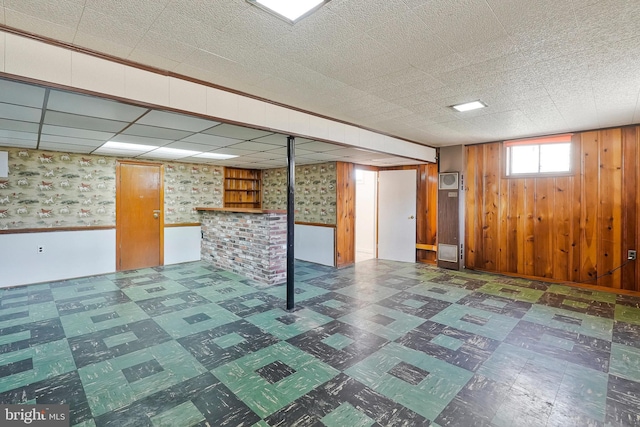 below grade area featuring wood walls, wainscoting, and tile patterned floors