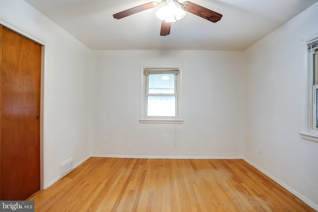 spare room featuring light wood-style flooring, visible vents, baseboards, and ceiling fan