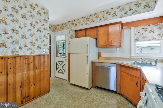 kitchen featuring white appliances, wainscoting, and wallpapered walls