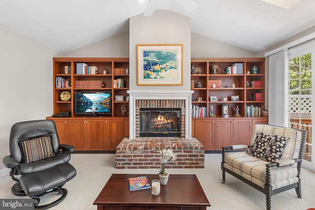 living room with lofted ceiling, a fireplace, carpet flooring, and a ceiling fan
