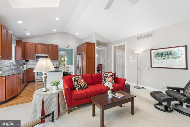 living room featuring vaulted ceiling, recessed lighting, ceiling fan, baseboards, and light carpet