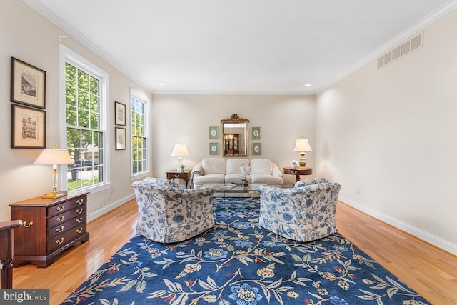 living area with light wood-style floors, baseboards, crown molding, and recessed lighting