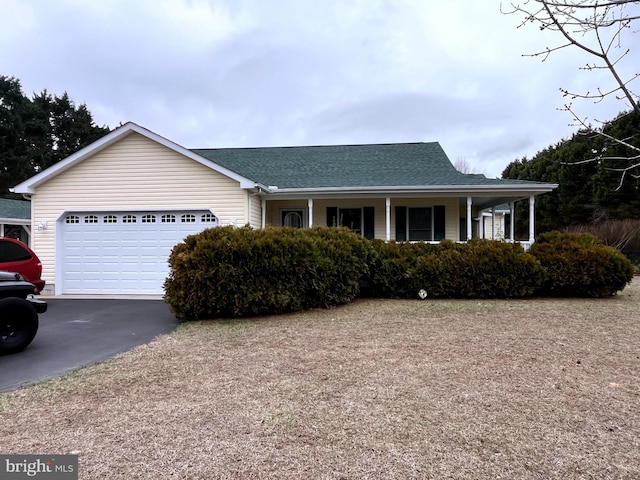 single story home with aphalt driveway, covered porch, roof with shingles, and an attached garage