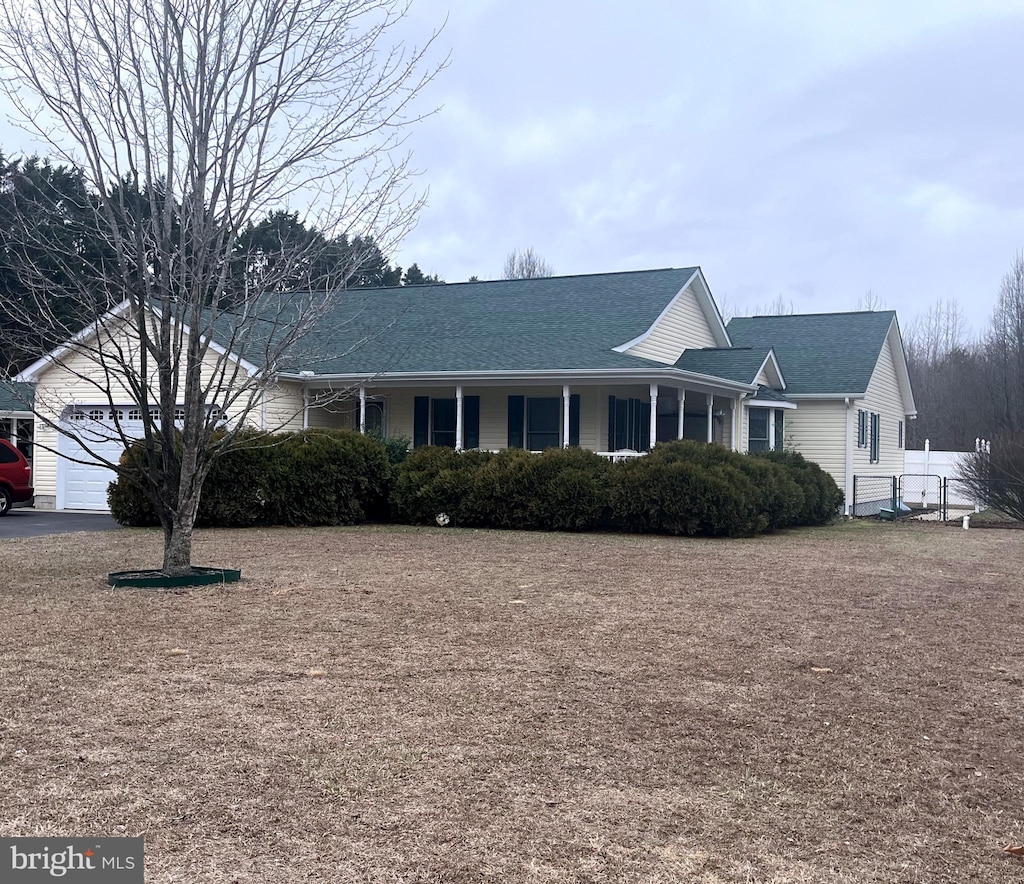 view of front of home featuring covered porch and a shingled roof