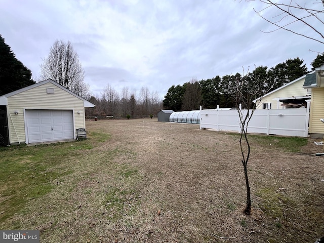 view of yard featuring fence and an outbuilding