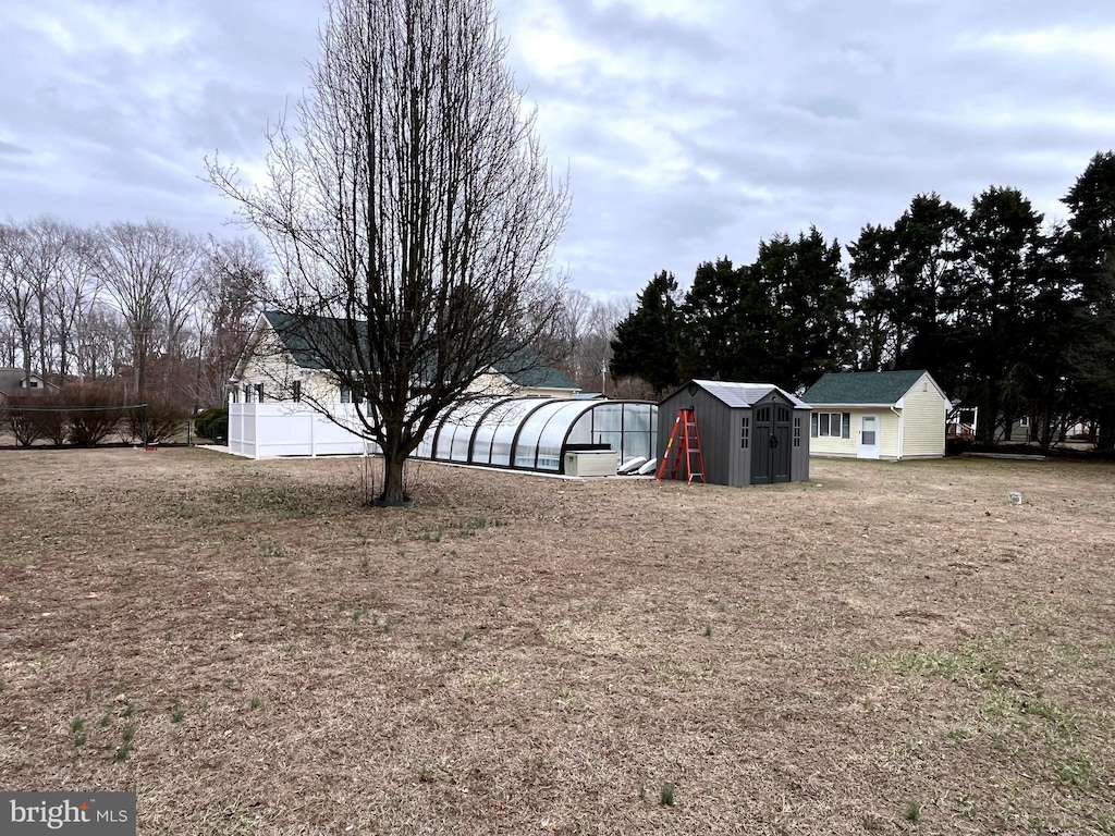 view of yard with an outbuilding, an exterior structure, and a storage shed