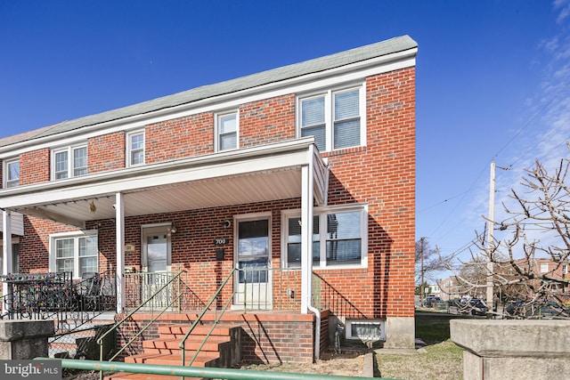 view of property featuring brick siding and covered porch