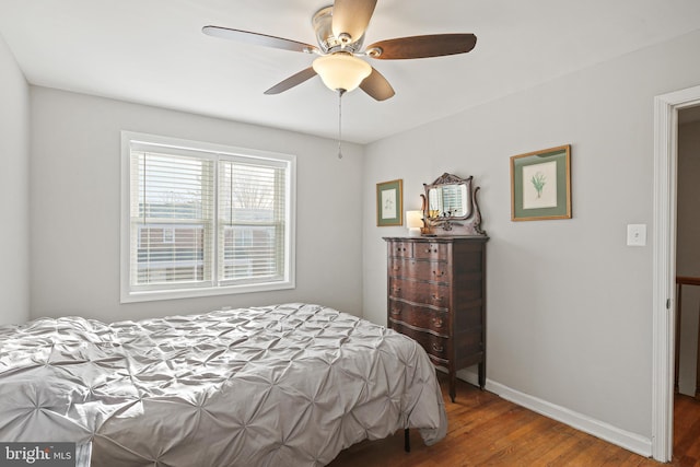 bedroom with baseboards, wood finished floors, and a ceiling fan