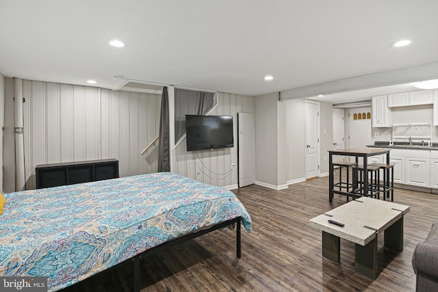 bedroom featuring recessed lighting, dark wood finished floors, and a sink