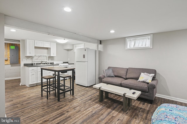 living area featuring electric panel, recessed lighting, dark wood-style floors, and baseboards