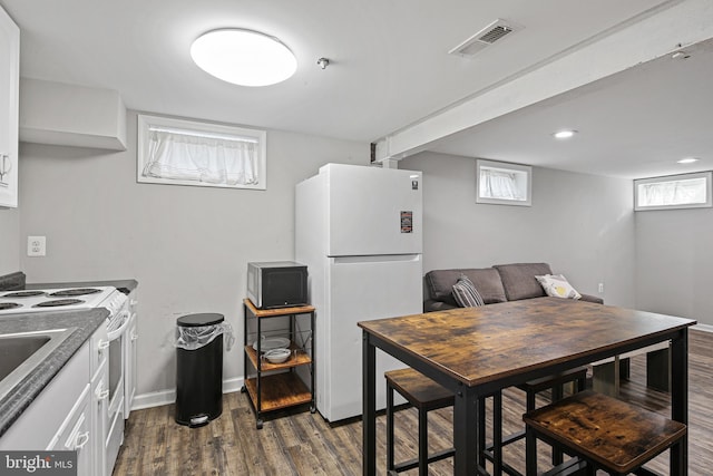 kitchen featuring dark wood finished floors, visible vents, white cabinets, and white appliances