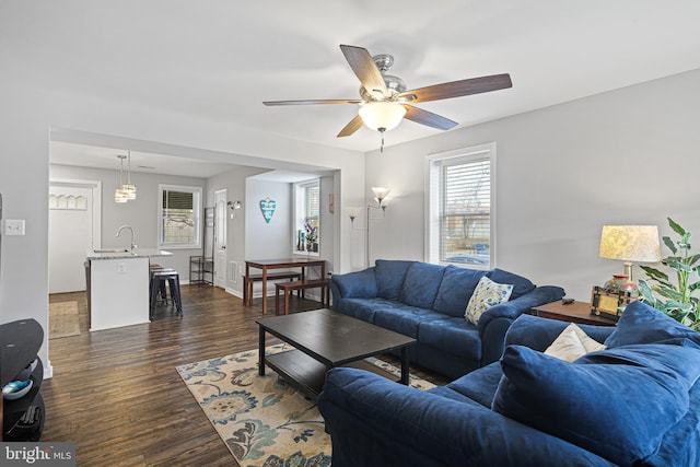 living room featuring a ceiling fan and dark wood-style flooring