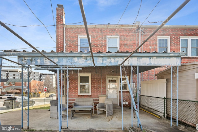 back of property featuring brick siding and fence