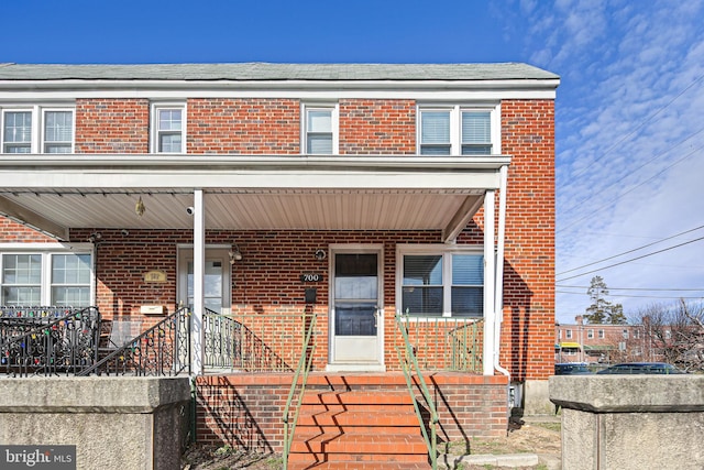 view of front of home featuring brick siding and covered porch