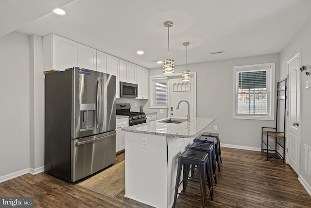 kitchen with dark wood finished floors, white cabinets, stainless steel appliances, and a sink