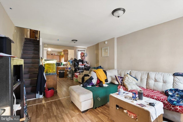 living area with stairway and wood finished floors