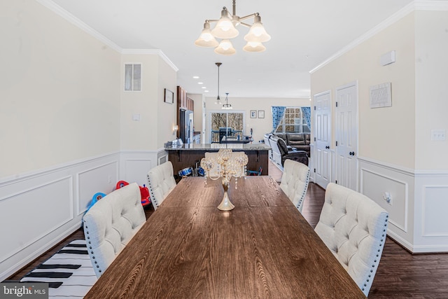 dining room with visible vents, dark wood finished floors, a notable chandelier, and ornamental molding