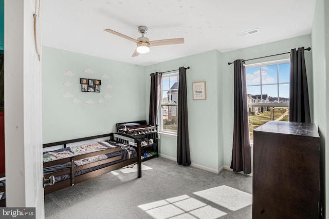 carpeted bedroom with ceiling fan, multiple windows, visible vents, and baseboards