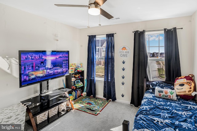 carpeted bedroom featuring visible vents, ceiling fan, baseboards, and multiple windows