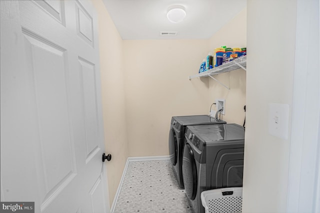 washroom with laundry area, independent washer and dryer, and baseboards