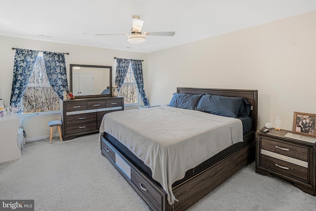 bedroom with light carpet, ceiling fan, visible vents, and baseboards