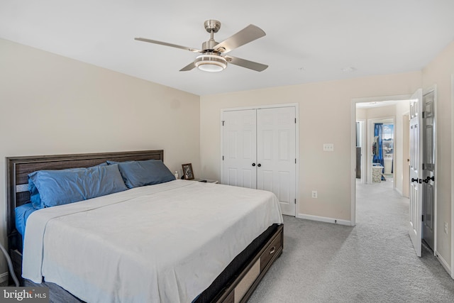 bedroom with light carpet, a closet, a ceiling fan, and baseboards