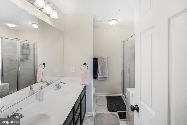 bathroom featuring a stall shower, baseboards, a sink, and tile patterned floors