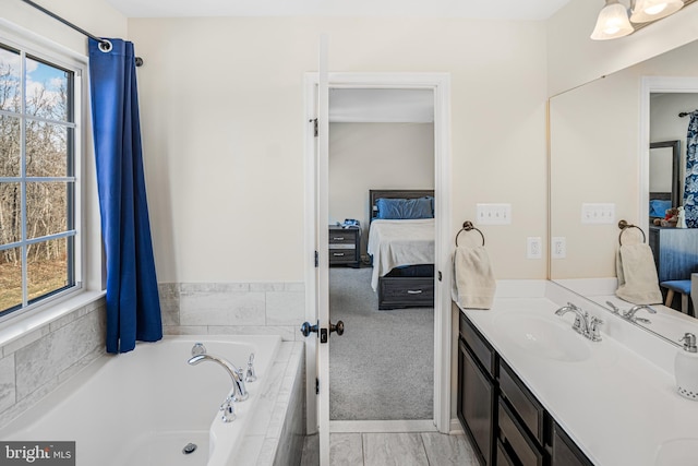 full bath with a garden tub, vanity, and ensuite bathroom